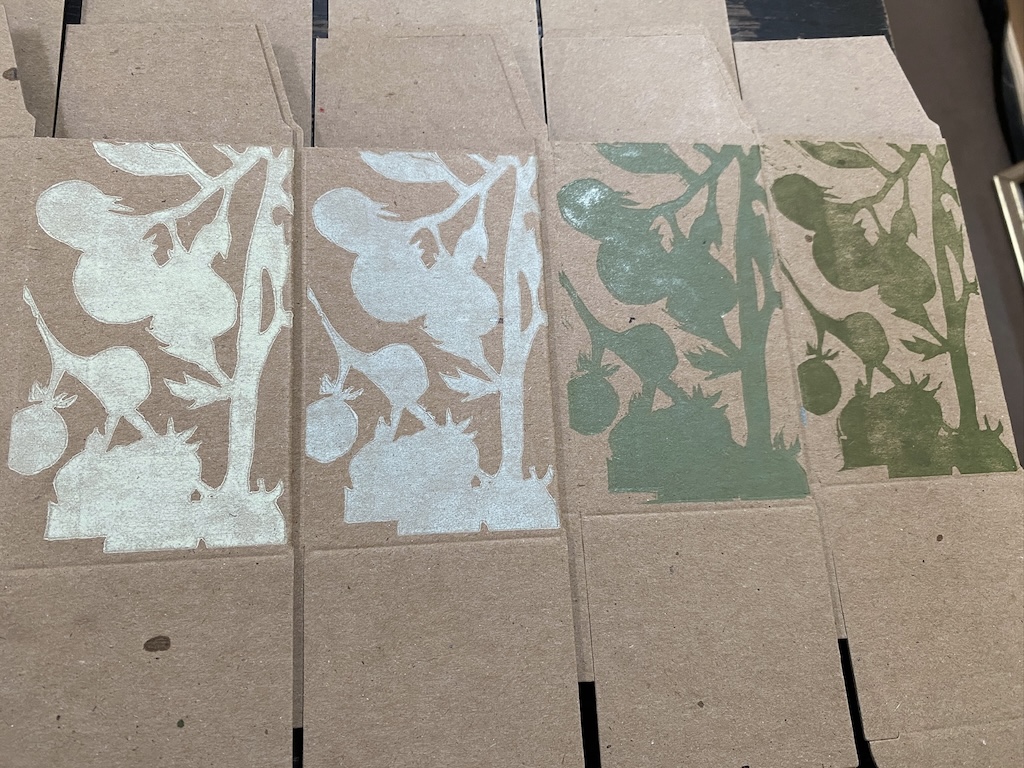 Four printed boxes, with the same image printed in increasing dark shades of green as you move from left to right.