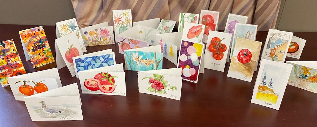 The collection of tomato notecards laid out on a table.