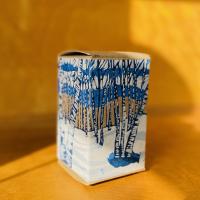 Cardboard box printed with a linocut image of birch trees.