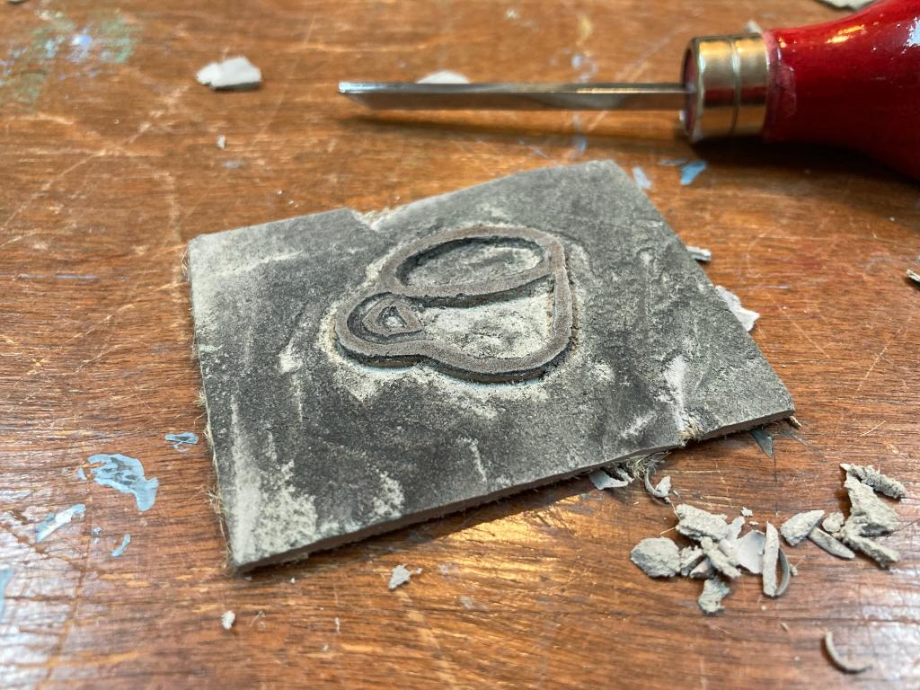 A small coffee cup carved into a lino block.