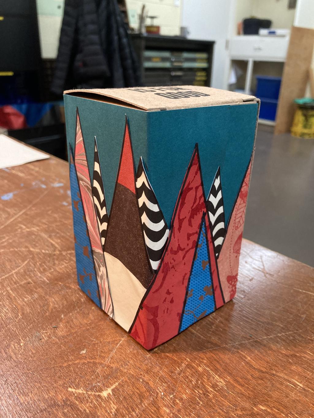 First prototype box, with collage on a brown box board box in the shape of trees.