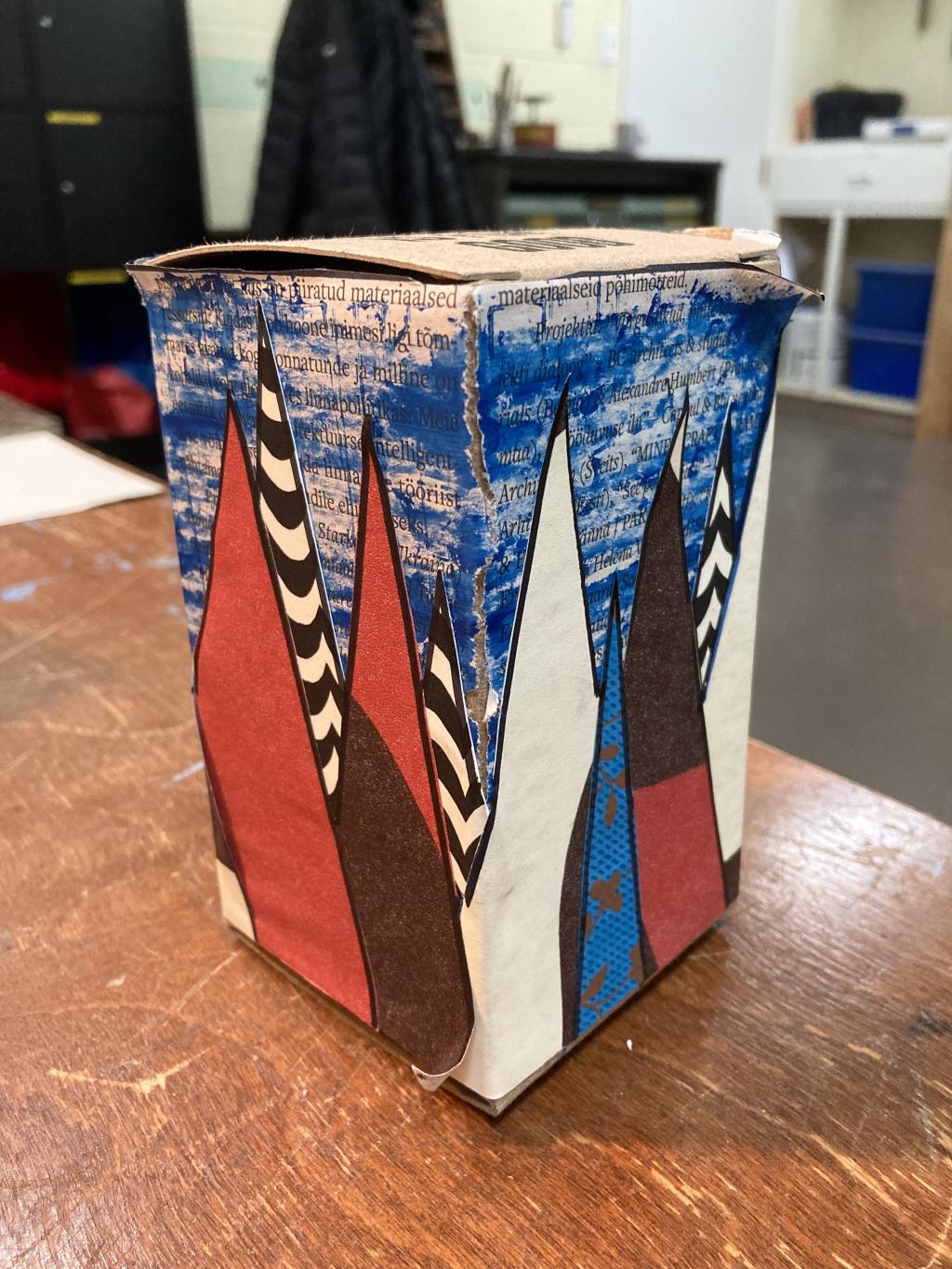 Second prototype box, with collage on a brown box board box in the shape of trees.