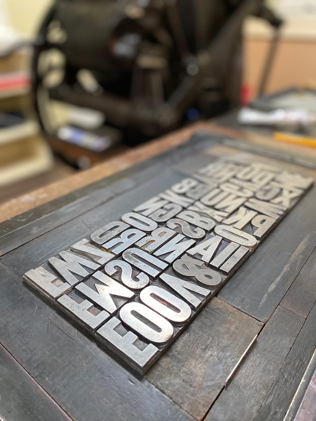 More large metal type in the letterpress chase.