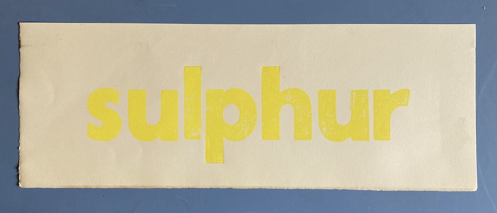 The work "sulphur" set in yellow type in a sans-serif typeface, lowercase, on beige paper.