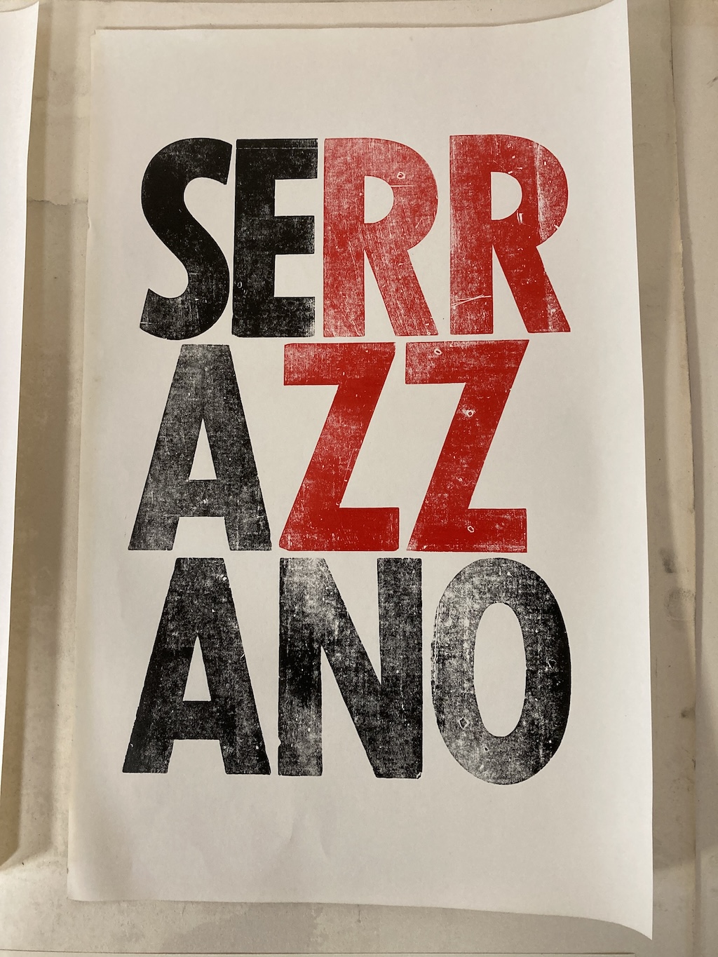 Serrazzano printing with large wood type, red and black, on white paper.