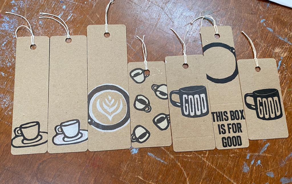 A collection of coffee-themed bookmarks, side by side on a brown wooden table.