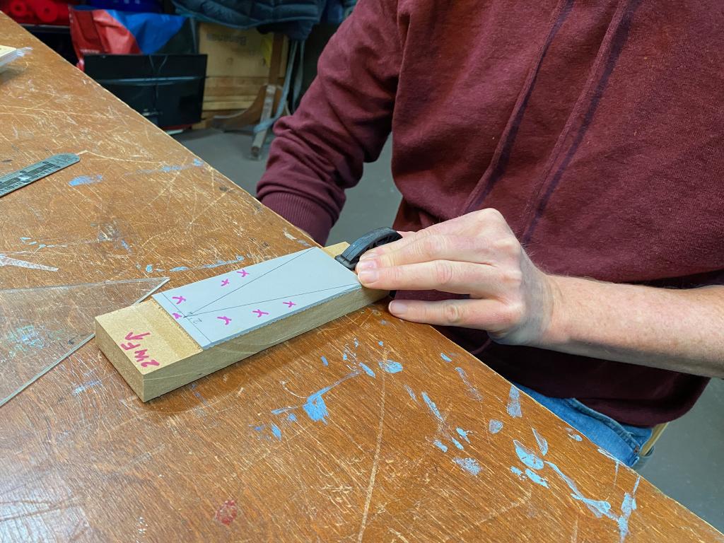 My hands, getting ready to carve a triangle out of a piece of lino block.