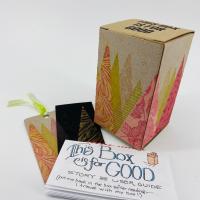 The "trees" box, showing gold, pink, and red abstract triangles printed on a brown boxboard box, with "This Box is for Good" printing on the top flap.