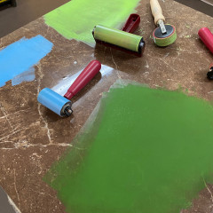 Blue, light green, and dark green ink rolled out on the ink mixing tile.