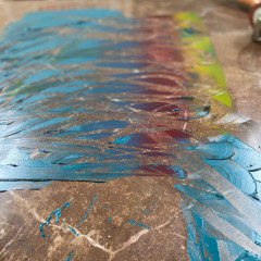 The "rainbow roll" ink on a floor tile being mixed.
