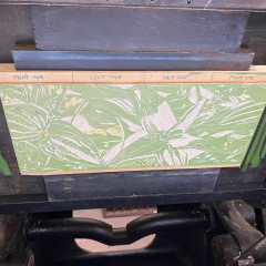 The mounted lino block in the chase, mounted on the letterpress.