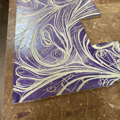 The carved lino block with purple ink.