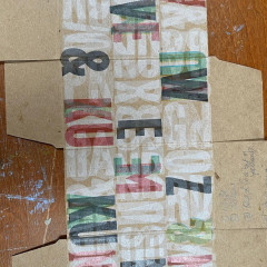 Black, red, and white layers, printed on boxes, laid flat to dry