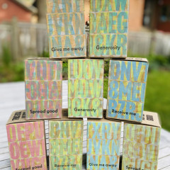 Nine printed, finished boxes, stacked two on three on four, on a wooden table
