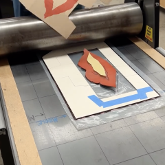 Lino block on the press, printed example