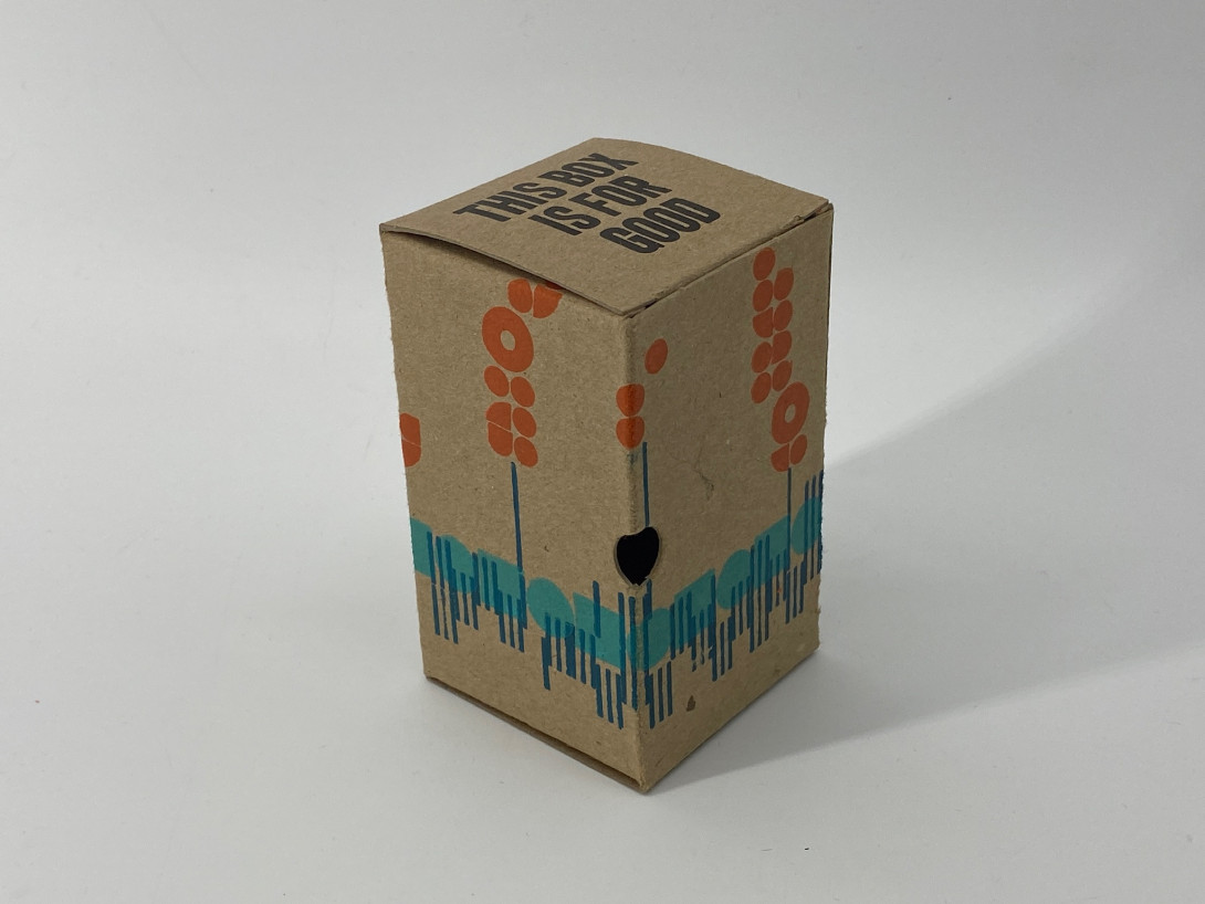 A brown cardboard box on a white background. Printed on the box are abstract shapes, in shades of blue and orange, giving the impression of lupins