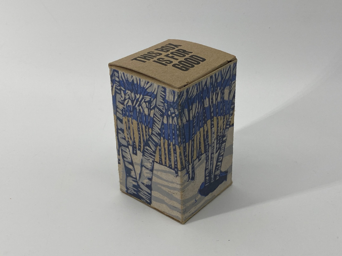 A brown cardboard box on a white background. Printed on the box, and white, black, and blue, are birch tree trees