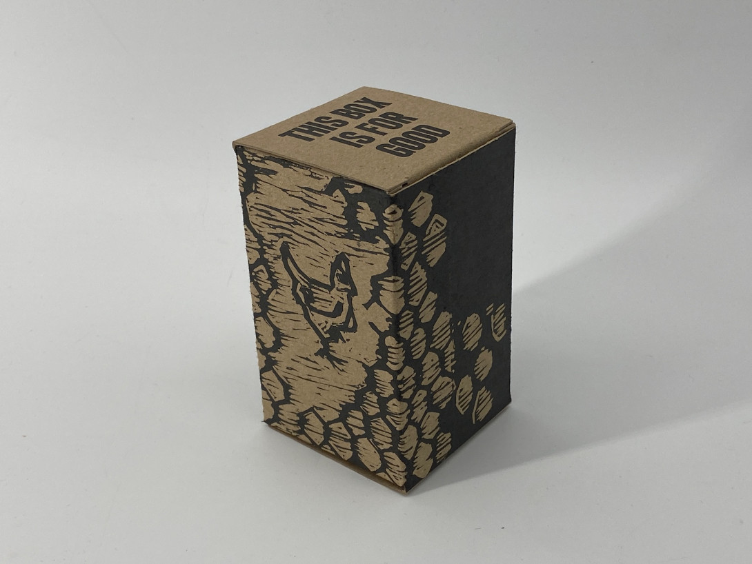 A brown cardboard box on a white background. Printed on the box, in black, are images of chickens, and abstract shapes