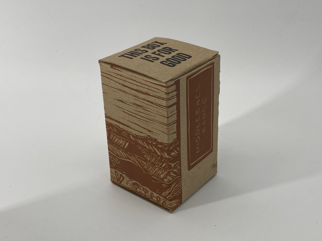 A brown cardboard box on a white background. Printed on the left panel, in brown, is a scene of the horizon. On the right panel, reading up from the bottom, are the words middleback range