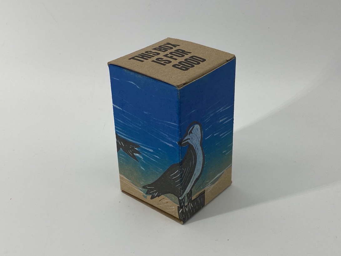 A brown cardboard box on a white background. Printed on the box is a single seagull, facing right, against a blue background